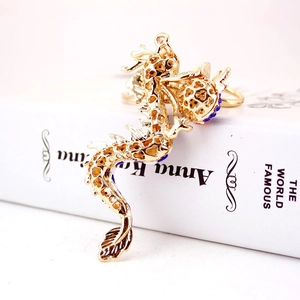 Exquisite golden dragon keychain with colorful rhinestones on a white book background