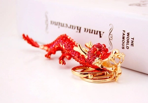 Vue détaillée du porte-clés dragon avec strass rouges et base en métal doré de qualité
