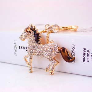 Sparkling crystal-encrusted horse keychain in gold-tone metal with elegant brown accents