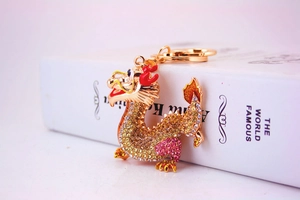 Close-up of golden Chinese dragon keychain with colorful rhinestones and red enamel