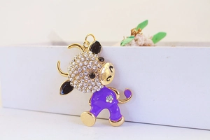 Detail of cute purple enamel ox keychain with sparkling rhinestones and gold alloy base