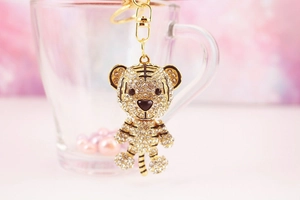 Close-up of sparkling crystal-studded cartoon tiger keychain with golden hook and ring