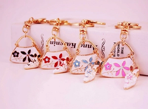 Detail view of four creative floral handbag keychains with stiletto heel charms on books