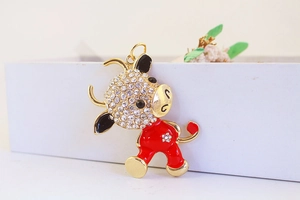 Close-up of golden ox keychain with white rhinestones and red enamel details