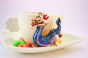 Close-up of a dragon keychain with sparkling blue rhinestones and gold-plated details
