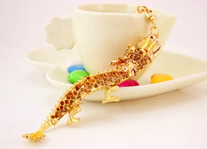Gros plan du porte-clés dragon doré orné de strass brillants sur une tasse en céramique