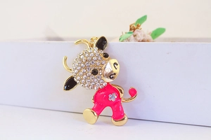 Detail of cute cartoon cow keychain featuring pink enamel and sparkling white rhinestones