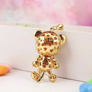Golden hollowed bear keychain with star patterns and a sparkling metallic finish