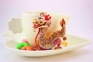 Detail of a golden dragon keychain pendant with sparkling rhinestones and red enamel