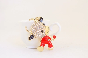 Close-up of cute cartoon ox keychain with white rhinestones and red enamel coating