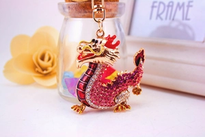 Detail of Chinese dragon keychain featuring intricate red crystal rhinestones and gold plating