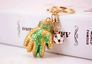 Detail of golden goalkeeper glove keychain with green enamel, rhinestones and mini soccer ball