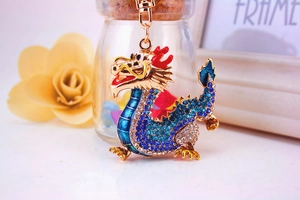 Detailed close-up of a golden Chinese dragon keychain with blue and white rhinestones