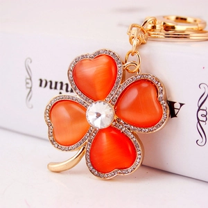 Luxurious four-leaf clover keychain with orange cat eye stones and sparkling rhinestones