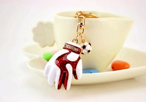 Detail of sports keychain with white baseball glove and soccer ball charm on a cup