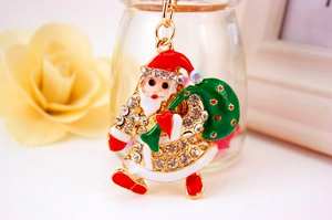 Macro view of Santa Claus keychain with colorful enamel coating and sparkling rhinestones