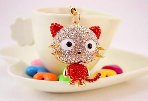 Close-up of cute cartoon cat keychain with sparkling red and white crystal rhinestones