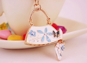 Detail of enamel handbag and high heel keychain with blue flowers and sparkling crystals