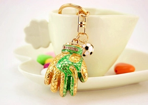 Detailed shot of a gold goalkeeper glove keychain with sparkling rhinestones and a small soccer ball