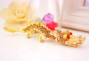 Macro d'un porte-clés dragon chinois doré orné de cristaux ambrés et de pierres rouges