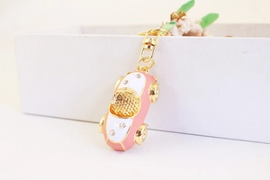 Detailaufnahme vom rosa Cartoon-Auto Schlüsselanhänger mit Strass und Gold-Elementen
