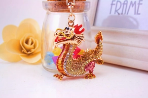 Detail of golden Chinese dragon keychain featuring intricate yellow and pink rhinestones