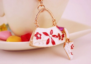 Detailed close-up of fashion handbag and high heel charms with red crystal butterfly