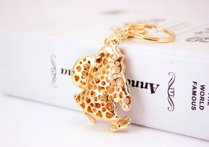 Detailed side view of golden Santa Claus keychain with hollow mesh design on book spine