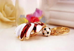 Detailed macro view of a soccer and baseball glove metal keychain with red and white finish