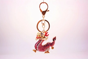 Detailed close-up of dragon keychain with pink rhinestones and gold plating