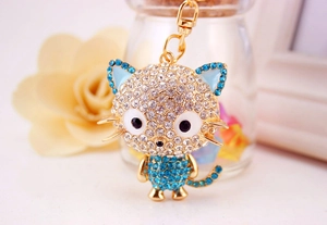 Close-up of cute crystal cartoon cat keychain with blue and white rhinestones