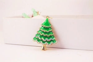 Detailed macro view of green enamel Christmas tree keychain with colorful rhinestones