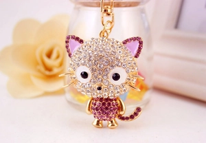 Close-up of sparkling purple crystal cartoon cat keychain with golden lobster clasp
