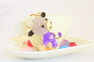 Detail of purple enamel cartoon cow keychain with sparkling rhinestones and gold alloy