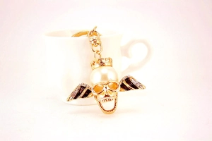 Detailed macro view of skull keychain with large pearl head and rhinestone crown
