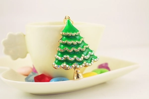 Macro detail of Christmas tree keychain with green enamel and sparkling rhinestones