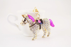 Detail of horse-shaped rhinestone keychain with pink enamel mane and golden lobster clasp