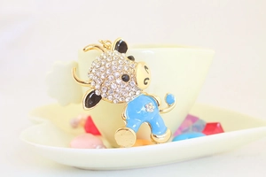 Detail of cute sky blue enamel ox keychain with sparkling white rhinestones on gold base