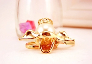 Detailed view of a golden crown pearl angel pig keychain with sparkling rhinestone wings