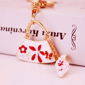 Creative white enamel handbag keychain with red flowers and rhinestone butterfly accents