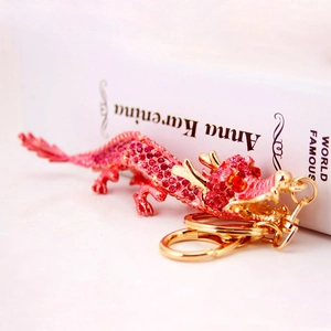 Porte-clés dragon chinois en strass rose avec finition alliage d'or sur livre blanc