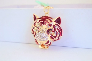 Vue détaillée du porte-clés tête de tigre avec émail rouge et strass brillants