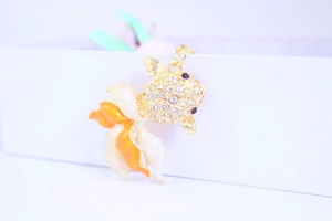 Macro detail of a goldfish pendant with sparkling rhinestones and orange enamel fins