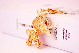 Macro shot of golden hollow ox keychain with heart patterns on a white book surface