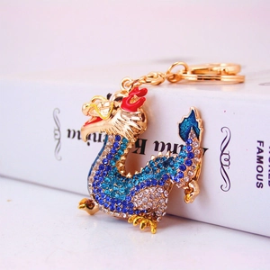 Chinese zodiac dragon keychain with blue crystals and gold plating on a book