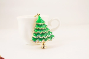 Macro detail of Christmas tree keychain with green enamel and sparkling rhinestones