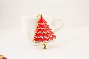 Close-up of a sparkling Christmas tree keychain with red enamel and white rhinestones