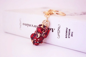 Macro view of Chinese Pi Xiu keychain with red enamel and sparkling rhinestones