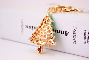 Close-up of golden Christmas tree keychain with heart hollow design and rhinestones