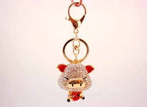 Dettaglio portachiavi a forma di maiale dorato con strass e orecchie in smalto rosso
